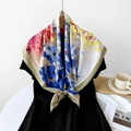 Vibrant floral silk scarf in blue and fuchsia hanging on a hanger with lifestyle props - Khaki Floral Print
