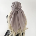 Detail view of mauve chiffon square headscarf tied on a mannequin with golden hair - Light Gray