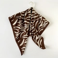 Brown zebra print silk scarf hanging on a gold hook against a white background - Coffee Zebra