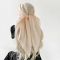 Elegante effen lichtroze chiffon hoofddoek geknoopt op lang haar achteraanzicht - Beige