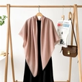 Detail of soft dusty pink pashmina shawl with tassel trim styled on a wooden hanger - Lotus Pink