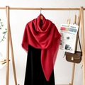 Detail of red oversized shawl with fringe edges styled with a black dress and newspaper - Dark Red