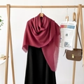 Close-up of wine red scarf featuring fine fringe details on a stylish wooden hanger - Wine Red