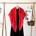 Detail of red oversized scarf with delicate fringe edges on a wood hanger - Crimson