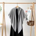 Detail shot of grey fringed shawl draped over a black dress with visible fabric texture - Light Gray