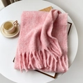 Pink mohair-style fluffy scarf with thick tassels shown in a warm cozy setting - Peach Pink