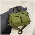 Detail of olive green multi-pocket tote bag with woven zipper pulls and wide shoulder strap - Green