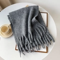 Thick grey mohair style scarf with long tassels placed on a white desk for winter - Dark Gray