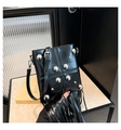 Detalle de un bolso negro vintage con flecos, remaches plateados y borlas largas - Negro
