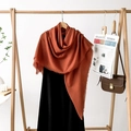 Caramel cotton-linen blend square scarf with fringe edges hanging on a wooden rack - Caramel
