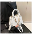 Detailansicht der weißen Handtasche mit Litschi-Textur, Goldnieten und Kettenverzierung - Weiß