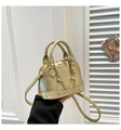 Detailaufnahme der champagner-goldenen Metallic-Handtasche mit Nieten und Ketten-Dekor - Gold