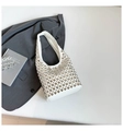 Dettaglio della borsa bianca con borchie metalliche argentate su sfondo di giacca grigia - Bianco