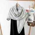Detail of white scarf with green geometric pattern draped on a black dress with wood hanger - Line Pattern White