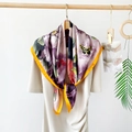 Detail view of a floral silk scarf with peony patterns and butterfly hanging on dress - Dark Violet
