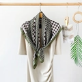 Detail of silk-like scarf featuring green houndstooth pattern tied on beige dress - Camellia Green