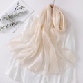 Detail of elegant champagne organza scarf with smooth glossy finish and fine hemmed edges - Beige