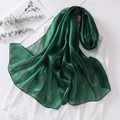 Detail of dark green organza headscarf showing translucent texture and soft sheen - Green