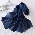 Macro view of navy blue organza headscarf showing glossy silk-like texture and soft drape - Blue