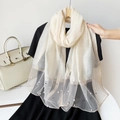 Detail of elegant cream faux silk scarf featuring delicate pearl bead embellishments - Beige