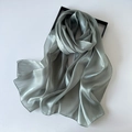 Close-up of sage green organza silk scarf with glossy texture on a gift box - Bean Green