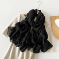 Pañuelo negro liso con textura de cuadros sutiles en una percha de madera natural - Negro