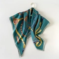 Detail view of the equestrian print silk-like scarf draped elegantly on a golden hanger - 90cmx90cm / Green