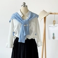 Light blue open-knit shawl draped over a white shirt and black pleated skirt ensemble - Light Blue
