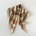 Vue détaillée d'un foulard en soie champagne avec des motifs imprimés de chaînes orange - Imprimé floral beige / Grand Carré