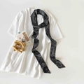 Detailed shot of black and white paisley skinny silk scarf styled on a white t-shirt - Black Paisley Print (P9003-Black Paisley)