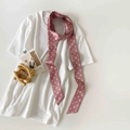 Detailed view of a pink polka dot narrow silk scarf styled on a white T-shirt - Pink Polka Dot (P9001-Pink)
