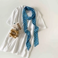 Close-up of blue polka dot skinny silk scarf styled on a white t-shirt neckline - Blue Polka Dot (P9001-Blue)