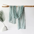Detail of grey-green pleated scarf hanging on wood branch with a minimalist aesthetic - 180x70cm / Green