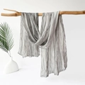 Detail view of silver grey pleated cotton linen scarf draped on a wooden branch - 180x70cm / Gray