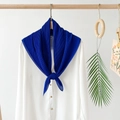 Detail of royal blue pleated silk scarf hanging on a minimalist wooden ring with palm leaf - Blue