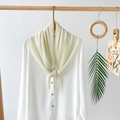 Detailed shot of beige pleated chiffon scarf paired with white long sleeve silk blouse - White