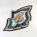 Detail of pleated silk scarf with navy and beige geometric patterns and wavy edges - Plissé Pleated / Blue Brown Grid