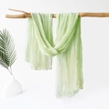 Light green crinkle textured scarf draped on a wooden branch with palm leaf decor - 180x70cm / Grass Green