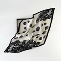 Detail of pleated silk scarf with black and white rose print on a minimalist tray - Plissé Pleated / Black and White Rose