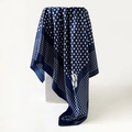 Elegant navy blue silk scarf with white polka dots and camellia flower print on display - Blue