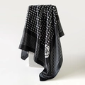 Polka dot and camellia flower silk scarf in black and white hanging on white stand - Black