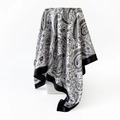 Detailed view of the black and white paisley satin scarf with floral patterns on a white stand - 90x90cm / Black (D9444)