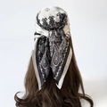 Close-up of silk square scarf with black and white paisley pattern tied as headscarf - L7014 / Black