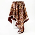 Foulard quadrato in seta satinata leopardata con bordo bianco su un supporto bianco - Marrone