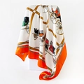 Macro detail of the 90cm square scarf featuring classic horse carriage and wheel prints - Orange