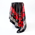 Close-up of glossy satin silk scarf featuring red floral and paisley patterns on black fabric - Black