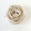 Elegant cream-colored lightweight linen scarf draped in a rose shape with fringe - Off-white