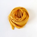 Ginger yellow cotton linen scarf wrapped in a rose shape with soft fringe edges - Turmeric