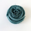Solid cyan linen cotton shawl scarf with fringe edges folded in a rose shape - Teal