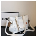 Detail of white canvas tote bag with brown flap pocket and mini round coin purse charm - White